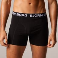 Man wearing black boxer briefs with "BJÖRN BORG" waistband, standing against a neutral background.