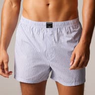 Man wearing blue and white striped boxer shorts against a neutral background, showing midriff and partial arms.