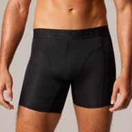 Man wearing black fitted boxer briefs with Björn Borg logo on waistband, showing a partial view of his torso and legs against a neutral background.