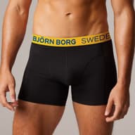 Man wearing black Björn Borg boxer briefs with a yellow waistband featuring "Sweden" text.