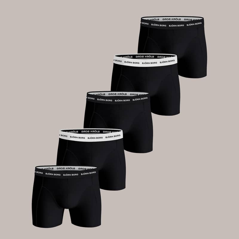Five pairs of black boxer briefs with branded waistbands arranged in a row on a neutral background.