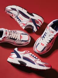 White, navy and red performance sneakers arranged on red background.