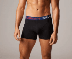 Man wearing black Björn Borg boxer briefs with a blue and red waistband, standing against a plain background.