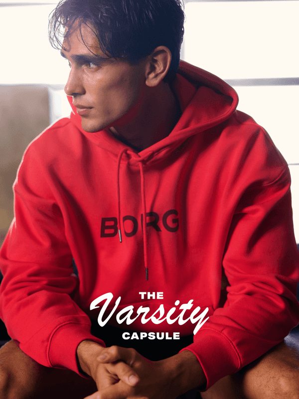 Person in a red hoodie with "BORG" on it, looking to the side. Text "The Varsity Capsule" on the image.