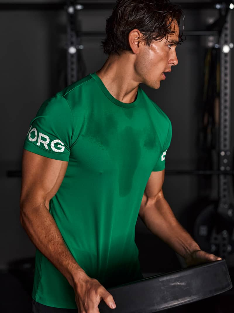 Man wearing a green Björn Borg training T-shirt in the gym.