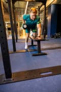 Man doing dumbbell row dressed in green t-shirt and shorts from Björn Borg
