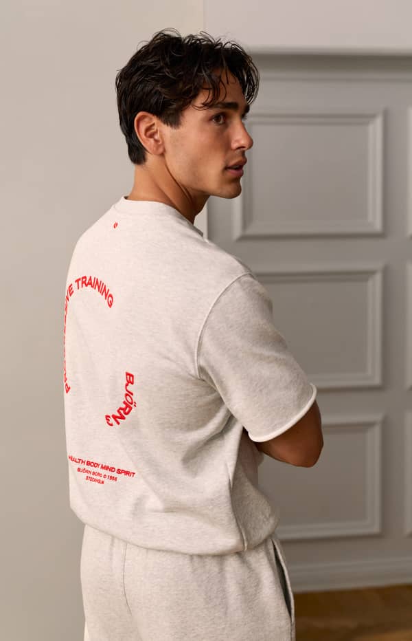 Man wearing a grey T-shirt with Progressive Training back print