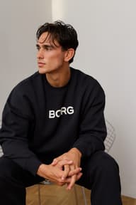 Man wearing a black Borg logo sweatshirt and matching joggers.