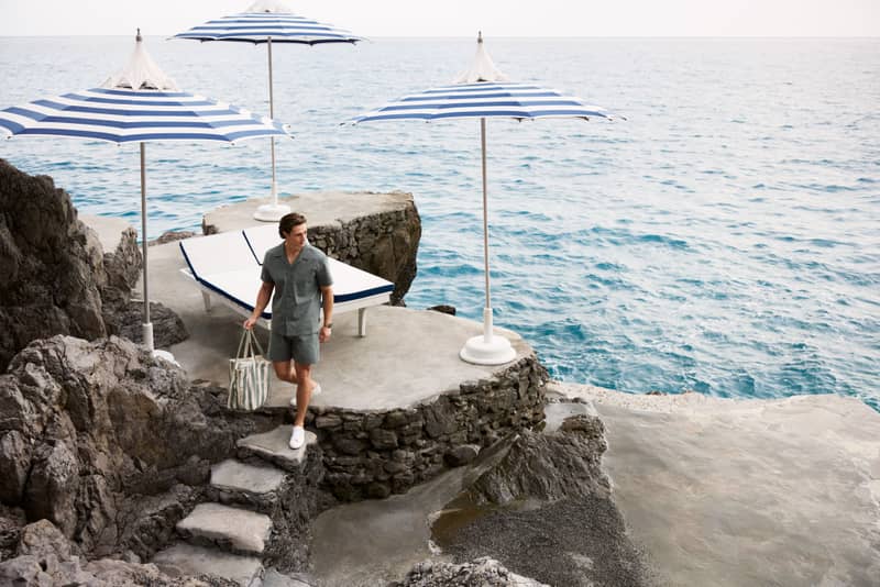 Man walking on rocks wearing a matching short-sleeve shirt and shorts set.
