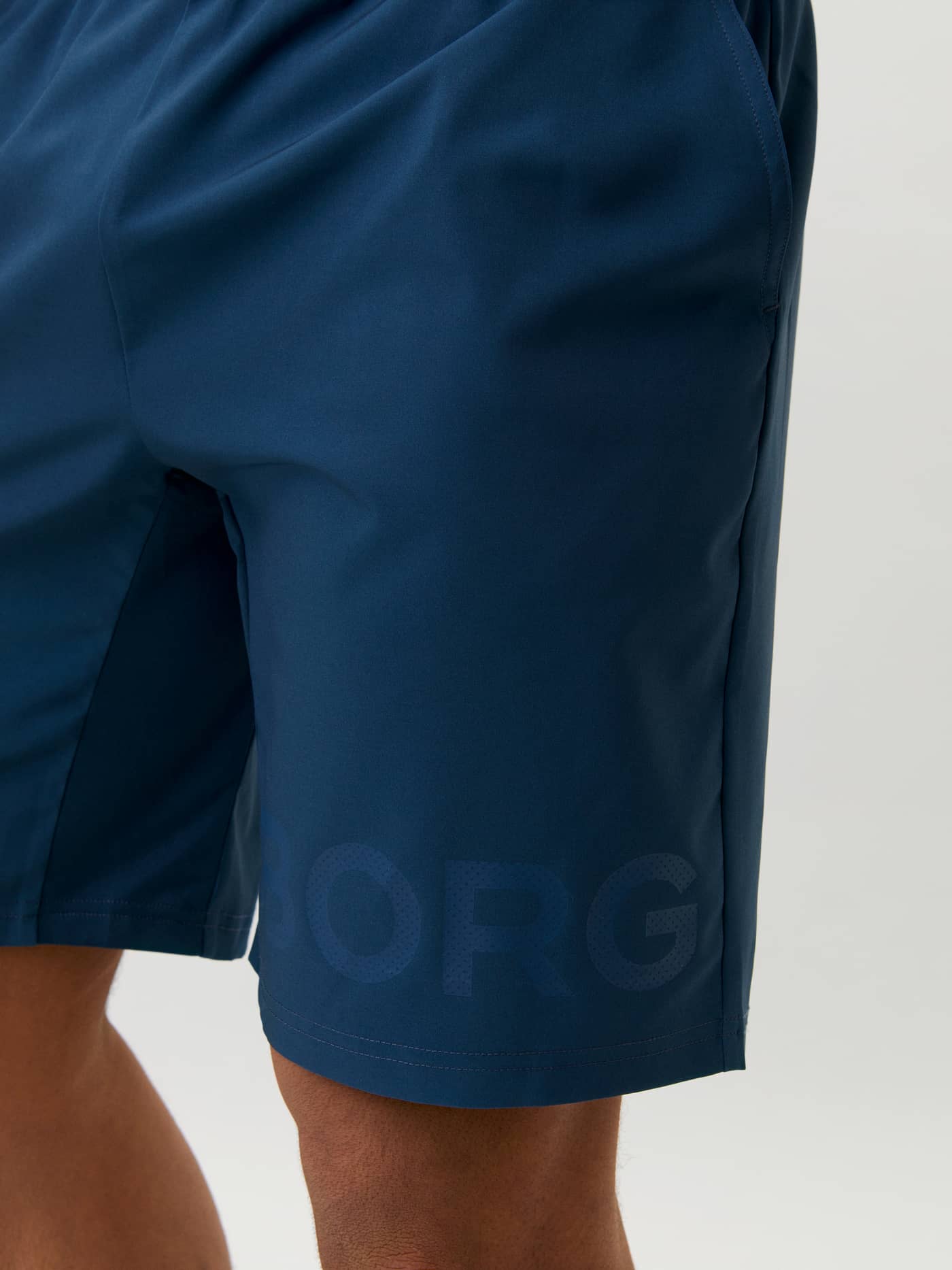 Close-up van de Borg Shorts in Navy (Marineblauw) voor heren met een tonaal logo en performance-stof voor training. - Image 4