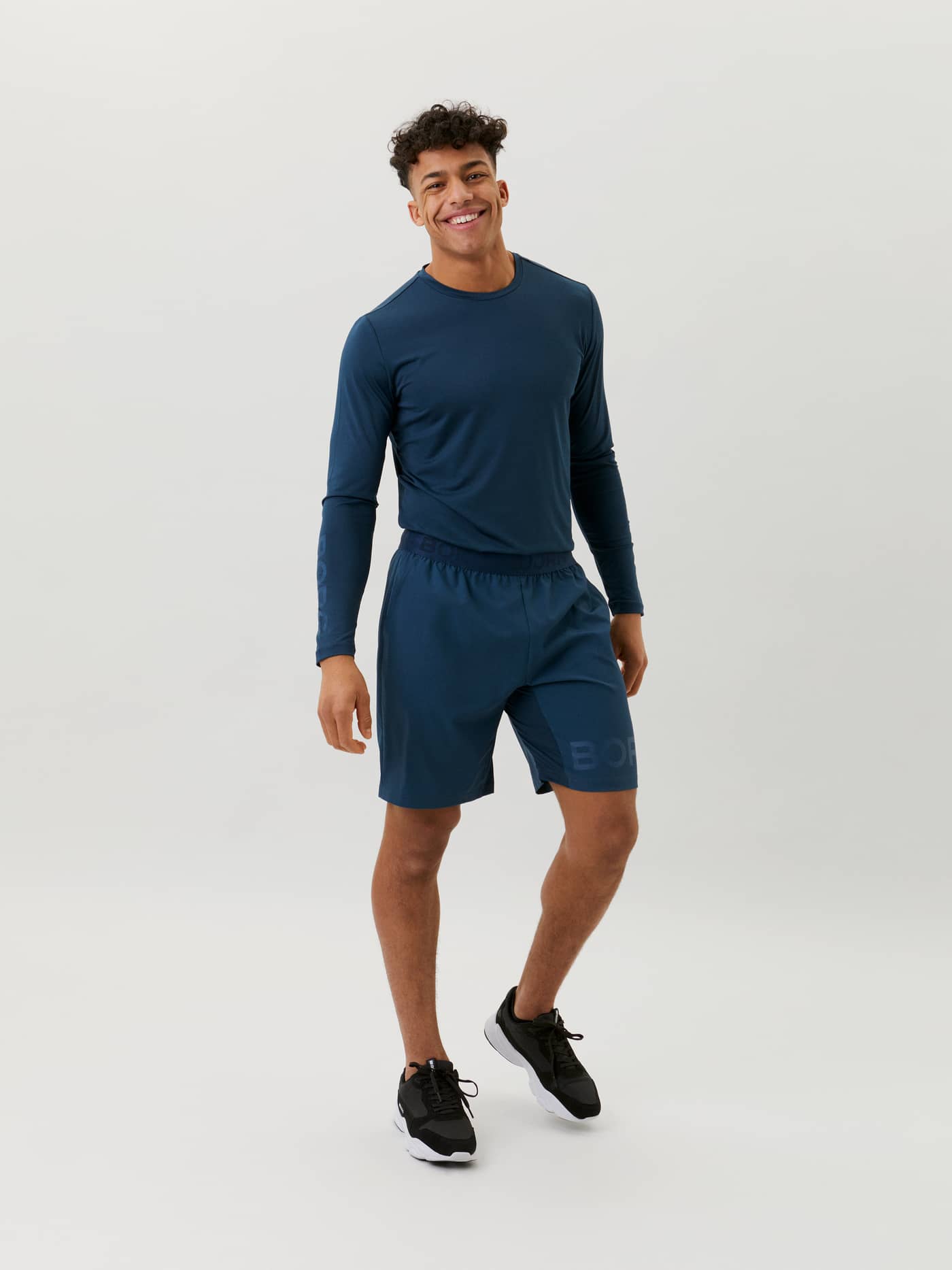 Full-body front view of a man wearing dark blue Björn Borg BORG SHORTS, with a functional design for performance training. - Image 1