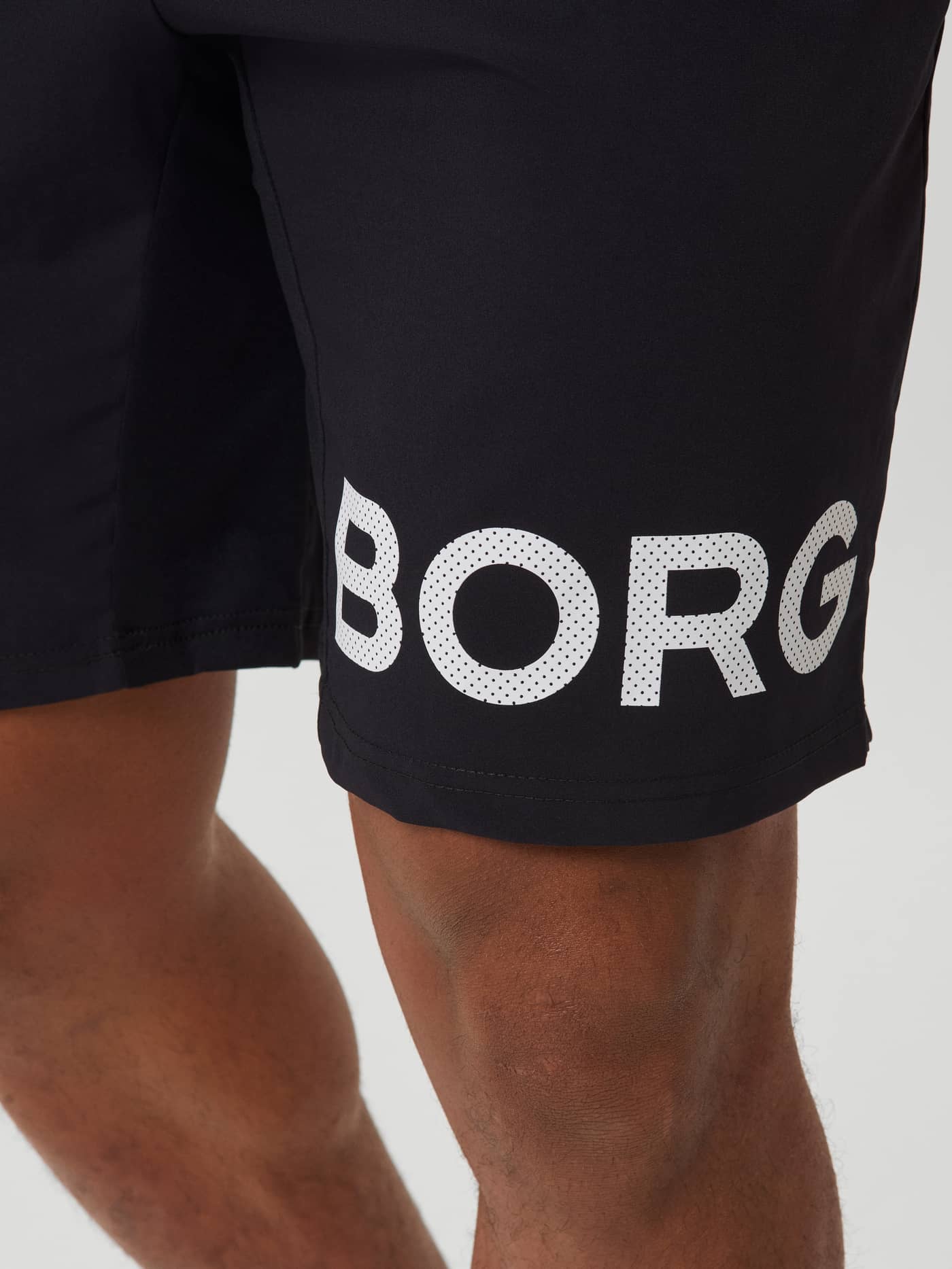 Black Beauty (Black) Borg Shorts in a detailed close-up, featuring a white logo on the leg for performance training. - Image 4