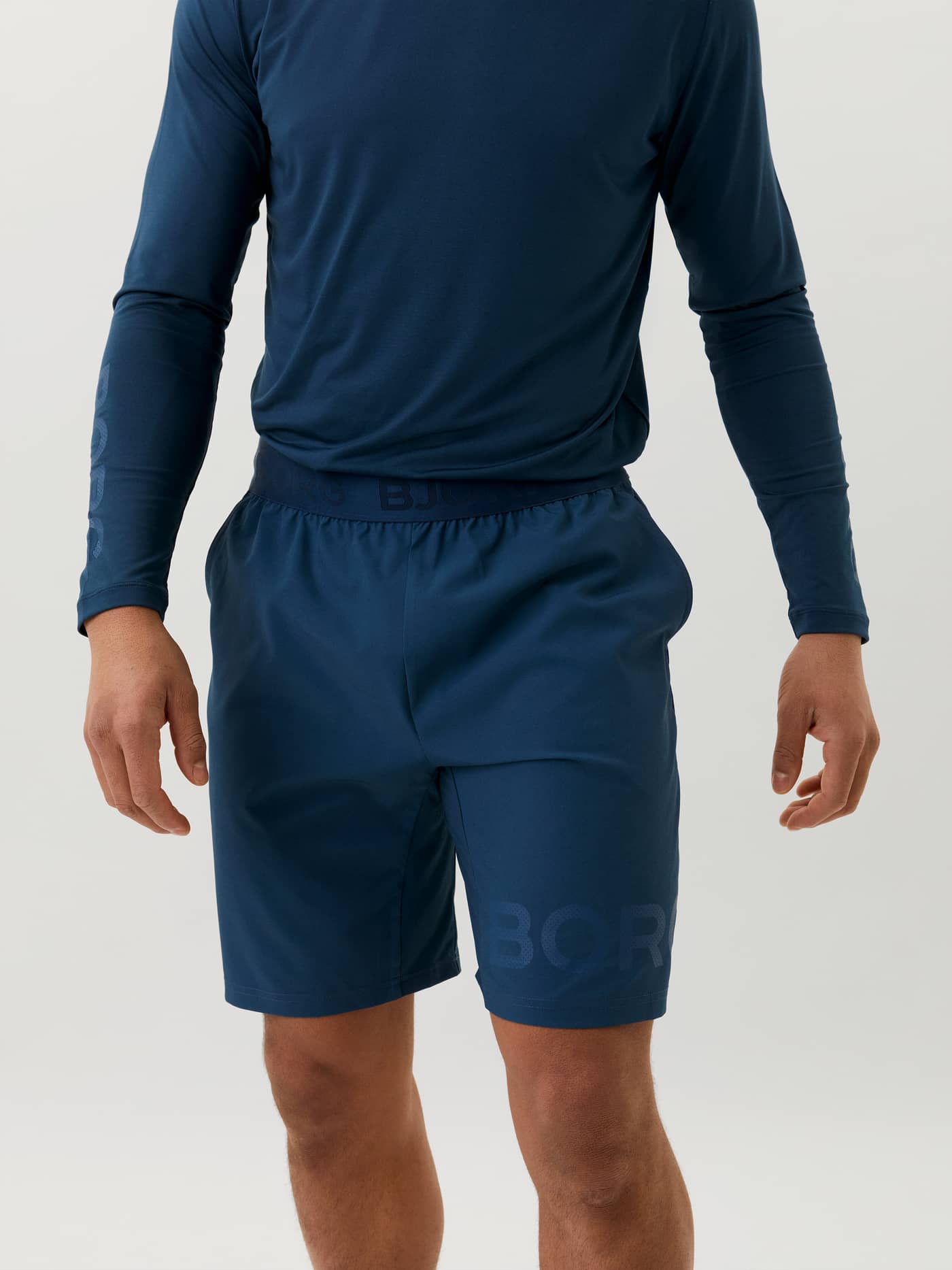 Vooraanzicht van een man in donkerblauwe (Blauw) Borg Shorts met logo op het been en iconische tailleband voor training. - Image 2