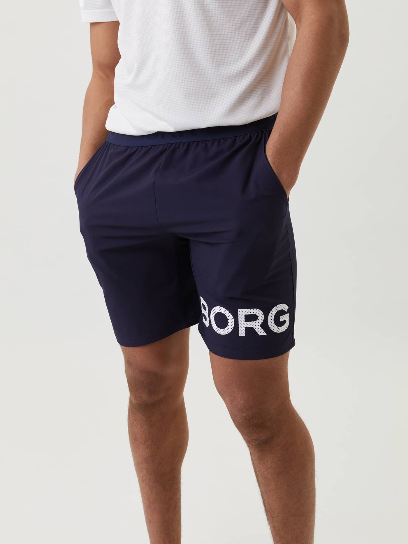 Front view of a man wearing functional, lightweight training Borg Shorts in Navy with a bold white logo. - Image 2