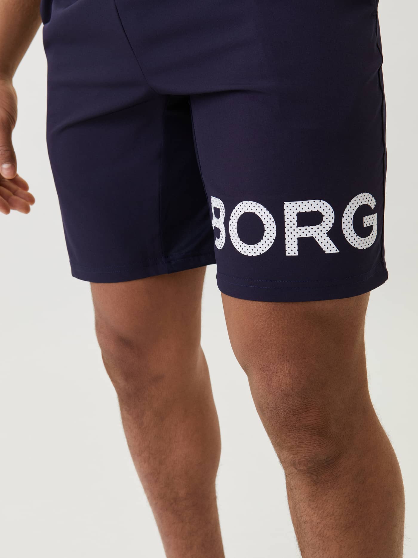 Close-up of the navy Borg Shorts for training, featuring a functional fit and bold white logo on the leg. - Image 4