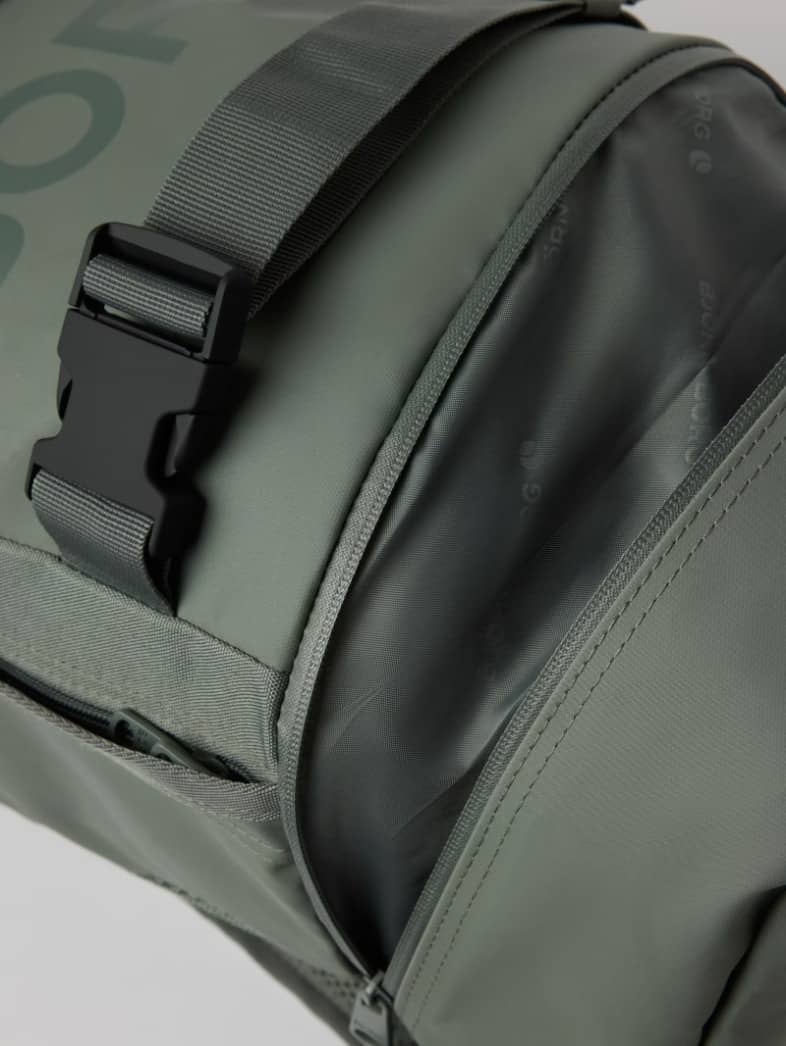 Detailed view of the training Borg Duffle Backpack 28L in Balsam Green (Green) featuring a zippered opening and buckle. - Image 4