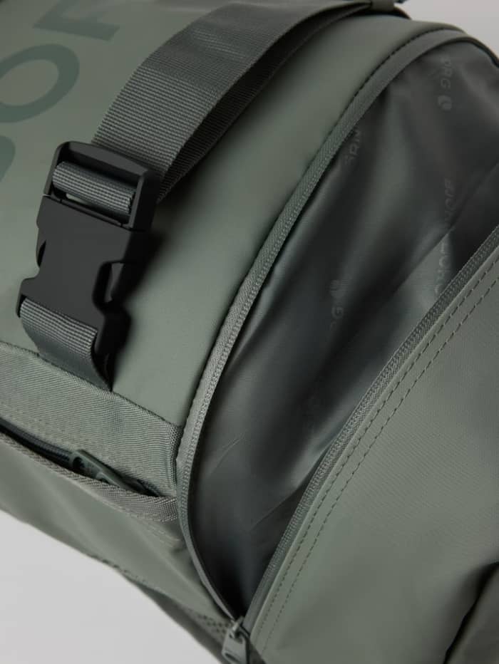 Detailed view of the training Borg Duffle Backpack 28L in Balsam Green (Green) featuring a zippered opening and buckle. - Image 4