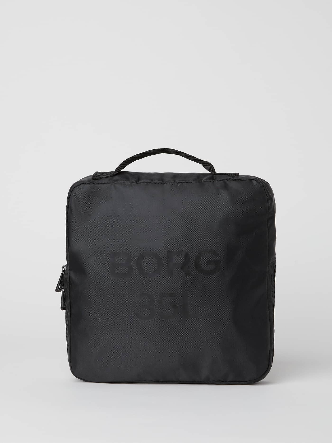 Front view of the black Borg Duffle Bag 35L folded into its own pocket, featuring a tonal logo and sturdy handle. - Image 6