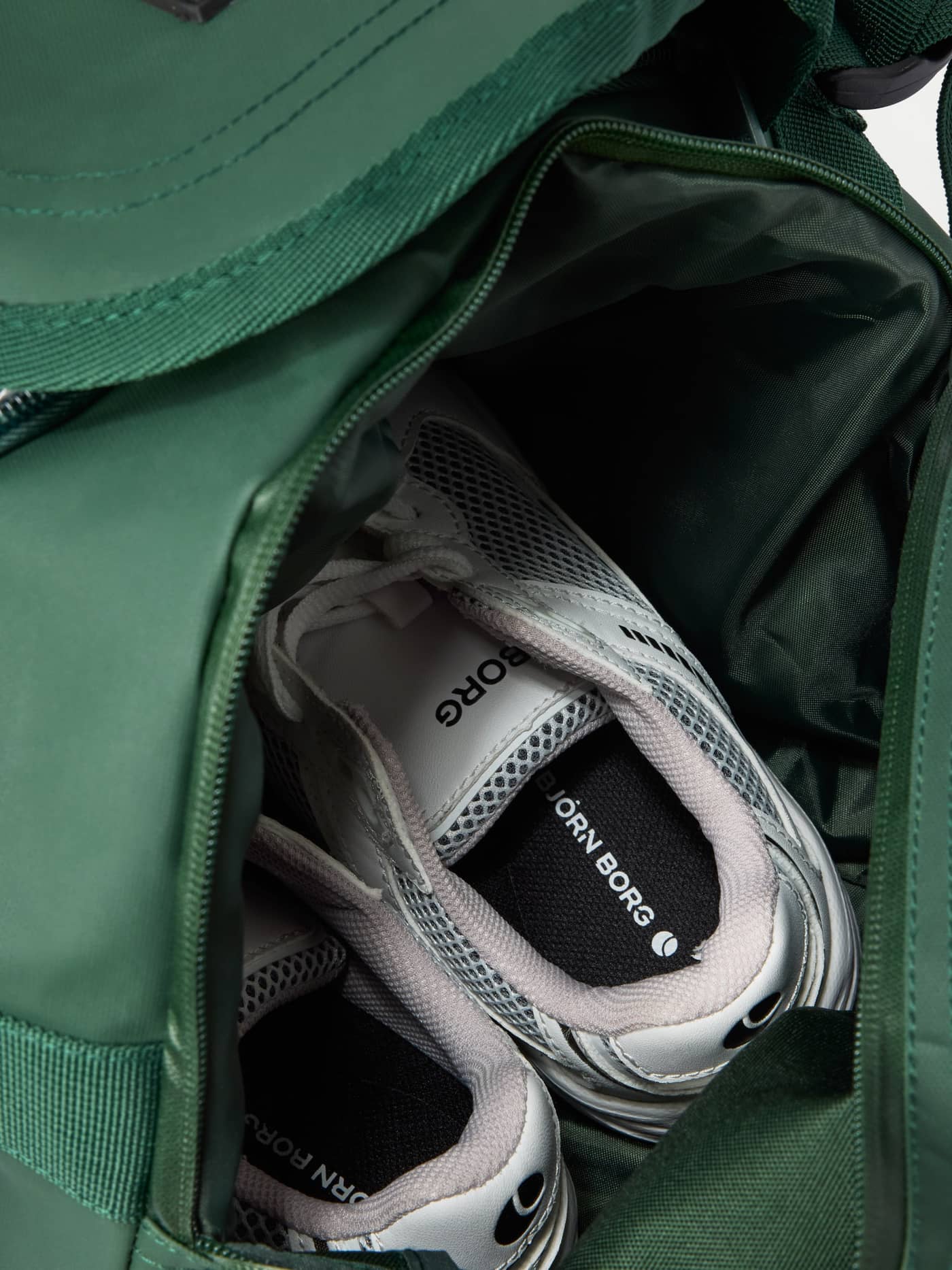 The water-resistant Borg Duffle Bag 35L in Mountain View (Green) featuring a dedicated shoe pocket for training gear. - Image 4