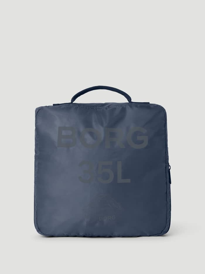 Borg Duffle Bag 35L i Night Sky (Marinblå) ihopvikt i sin fyrkantiga förvaringsväska med ett grått logotryck. - Image 3