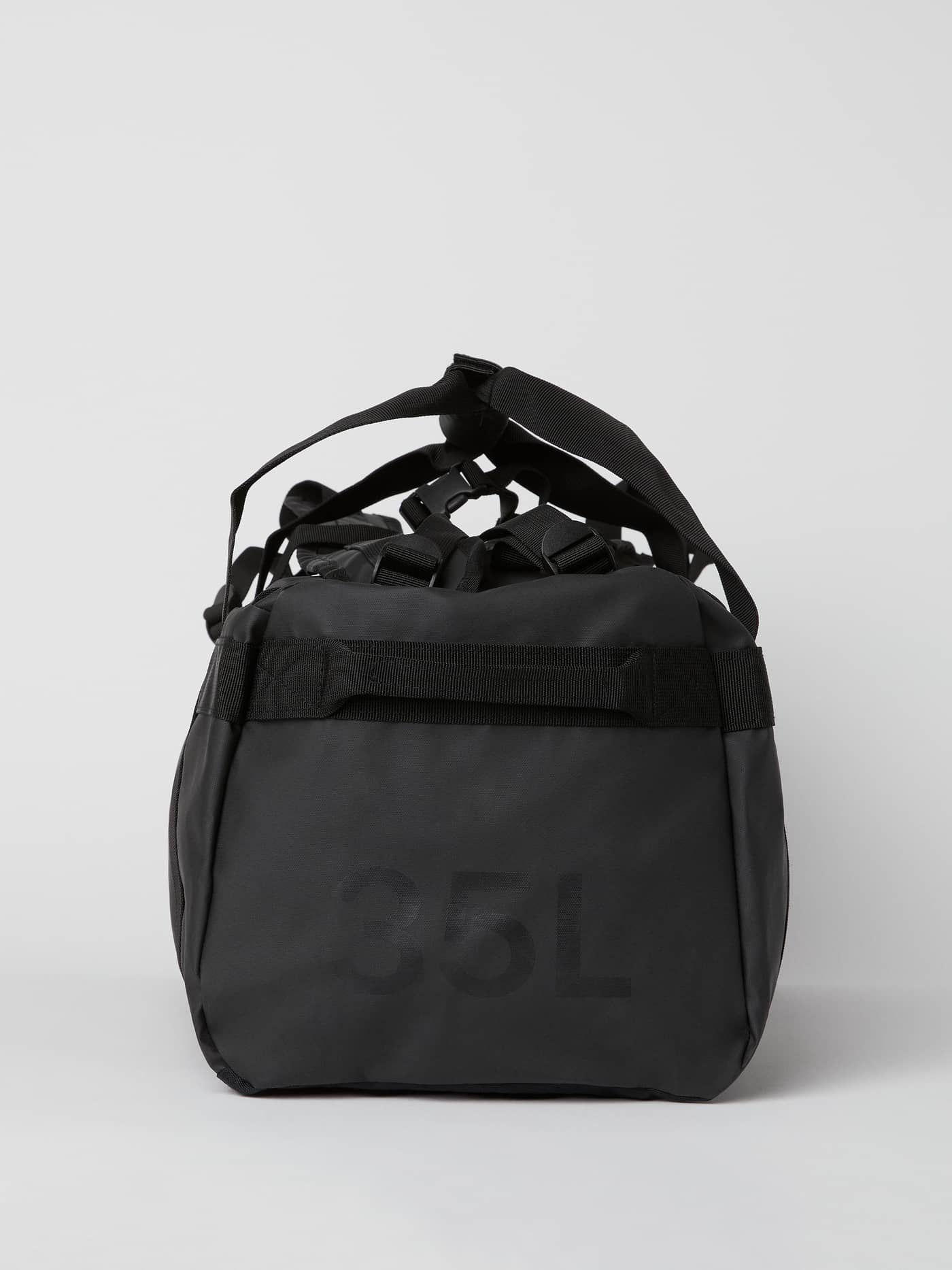 Side view of the black Borg Duffle Bag 35L, featuring a sturdy, performance-ready design and tonal 35L logo for training. - Image 4