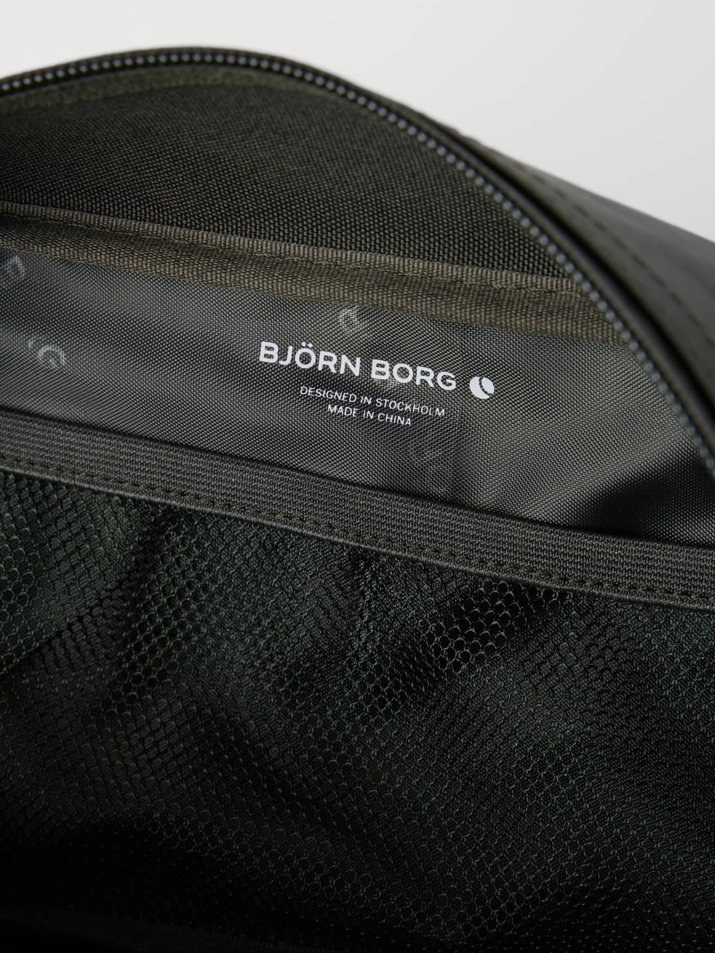 Detailed interior of the Borg Duffle Wash Bag in Forest Night (Green) with a functional mesh pocket and white logo. - Image 3
