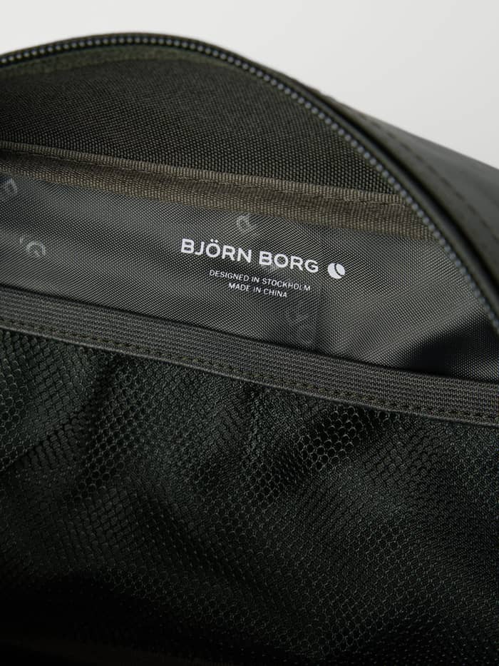 Gedetailleerd interieur van de Borg Duffle Wash Bag in Forest Night (Groen) met een meshvak en wit logo. - Image 3