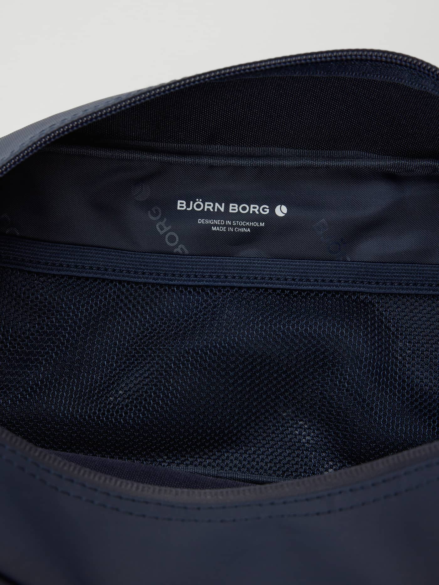 Interior view of the Borg Duffle Wash Bag in Night sky (Navy) with mesh pockets for training and a white logo. - Image 3
