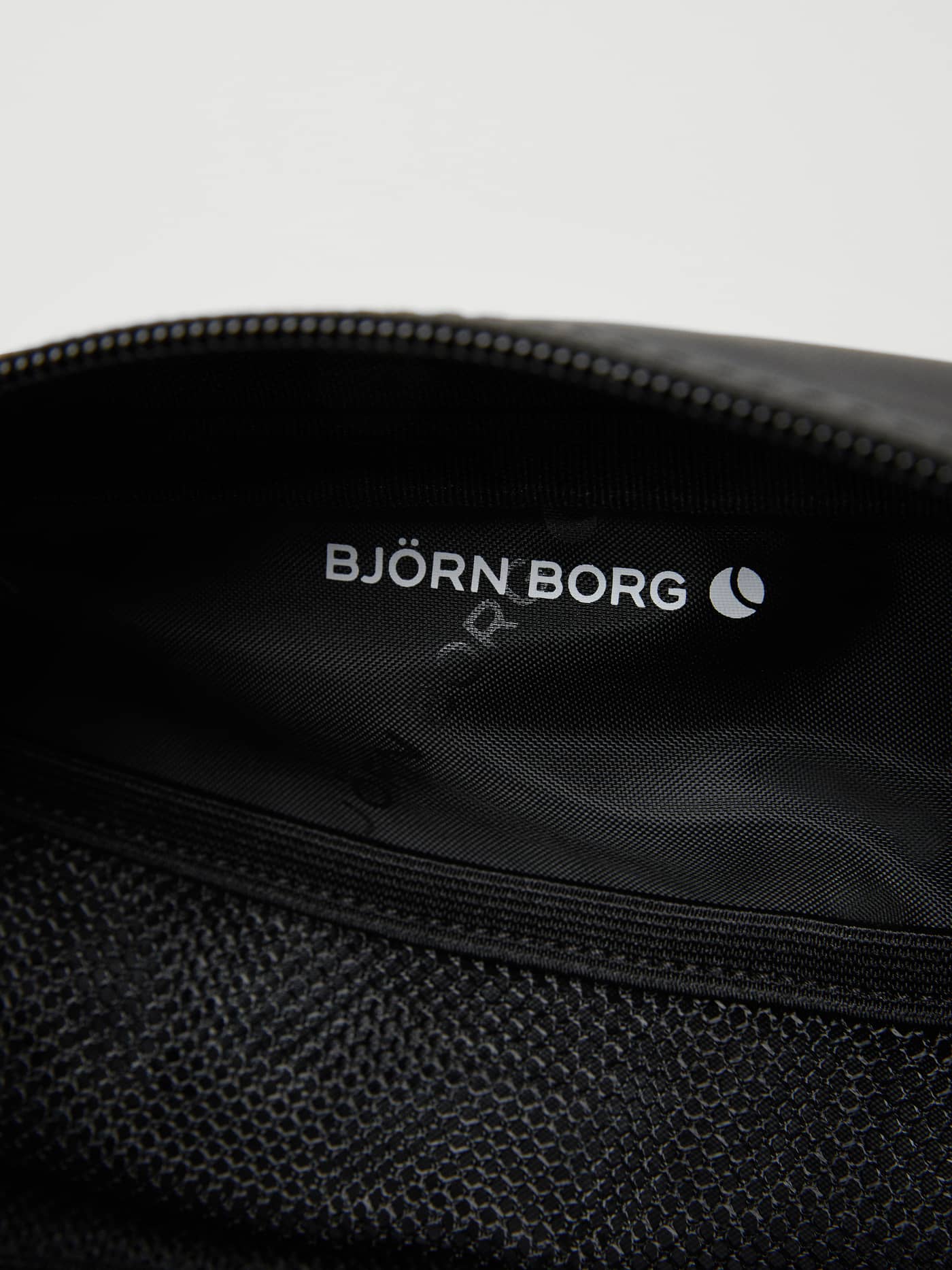 Interior view of the Borg Duffle Toilet Case in Black Beauty (Black) showing the white logo and mesh training pocket. - Image 3