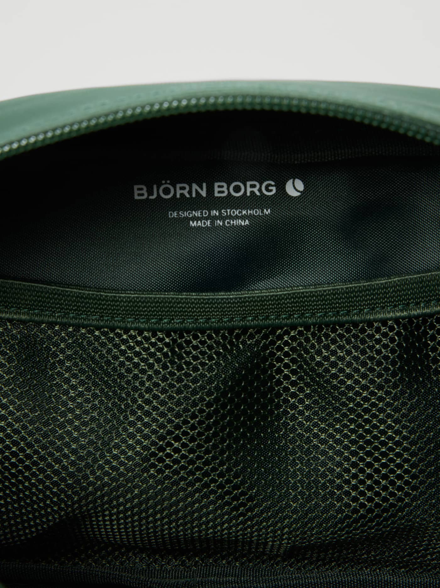 Innenansicht der Borg Duffle Wash Bag in Mountain View (Grün) mit Netztasche und weißem Logo für Trainingsutensilien. - Image 3