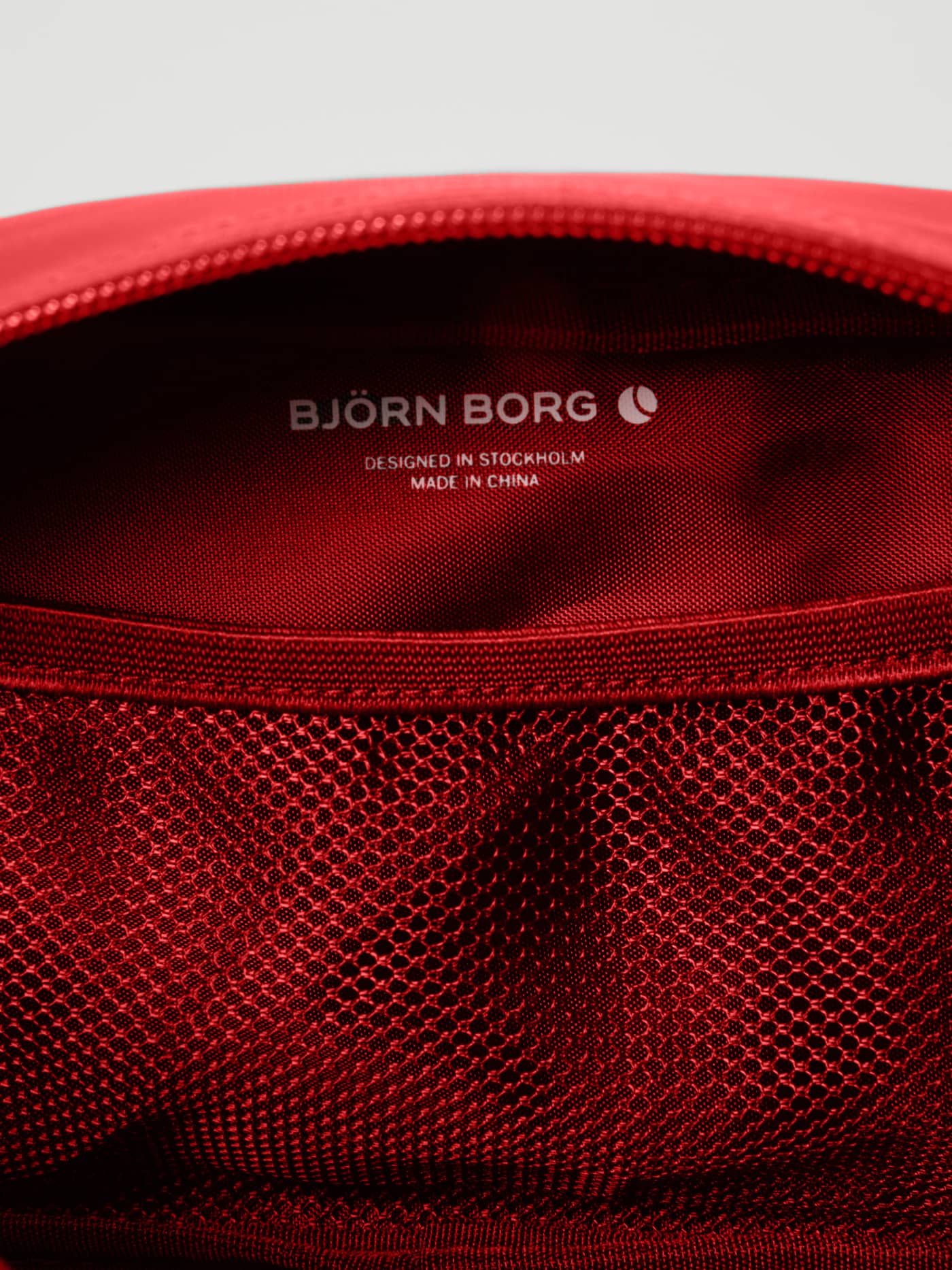 Internal detail of the Borg Duffle Wash Bag in Samba (Red), featuring a mesh pocket and white Björn Borg logo. - Image 3