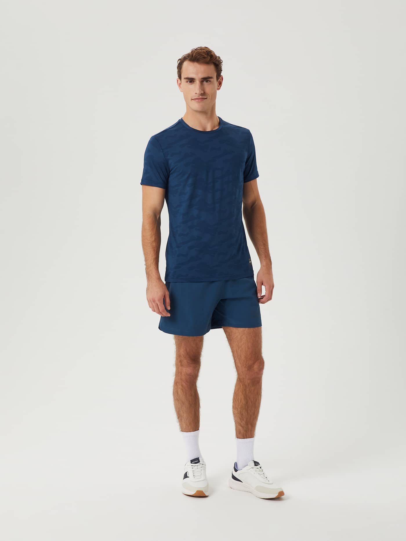Full-body front view of a man in the functional, recycled Borg Short Shorts in Blue Wing Teal (Blue) for training. - Image 2
