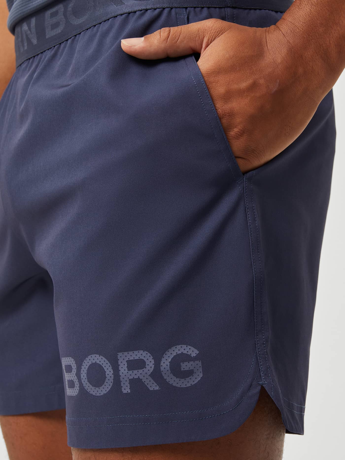 Närbild på Borg Short Shorts för träning i Odyssey Gray (Blå) med sidoficka och en ton-i-ton-logotyp på benet. - Image 4