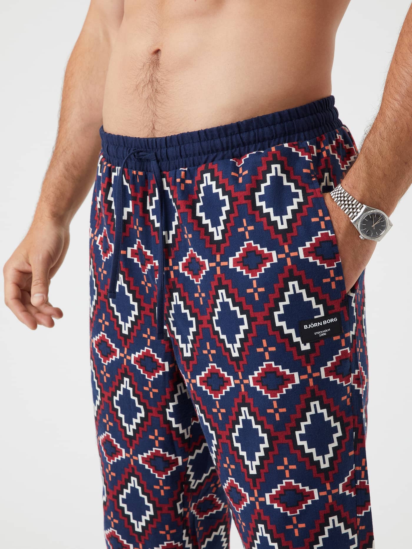 Close-up of a man wearing Björn Borg Core Flannel Pyjama Pants with a geometric tribe print in blue, red, and white. - Image 4