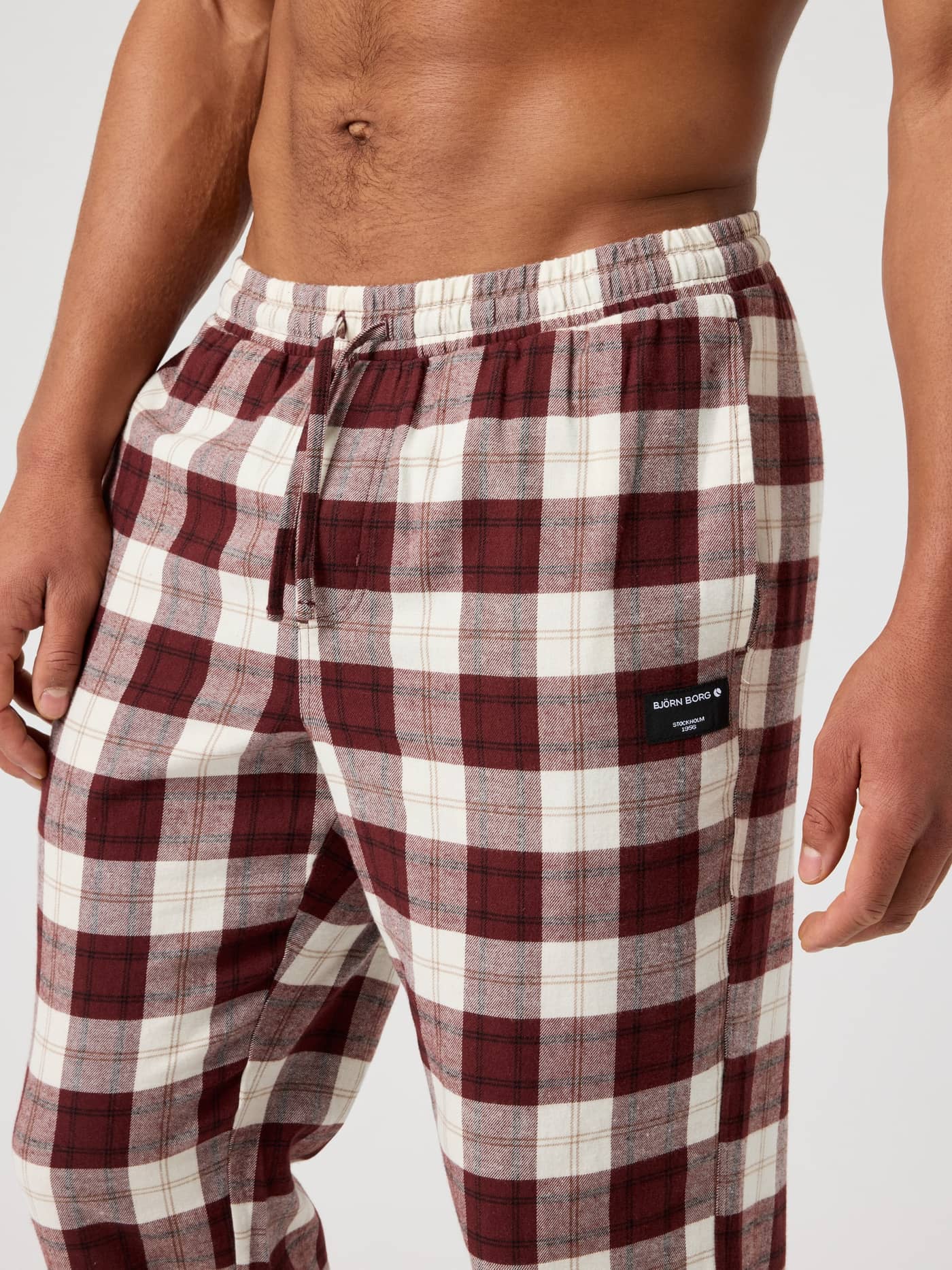 Close-up of men's Core Flannel Pyjama Pants in Forest Tartan 6 (Red) with soft brushed flannel and a black logo tag. - Image 4