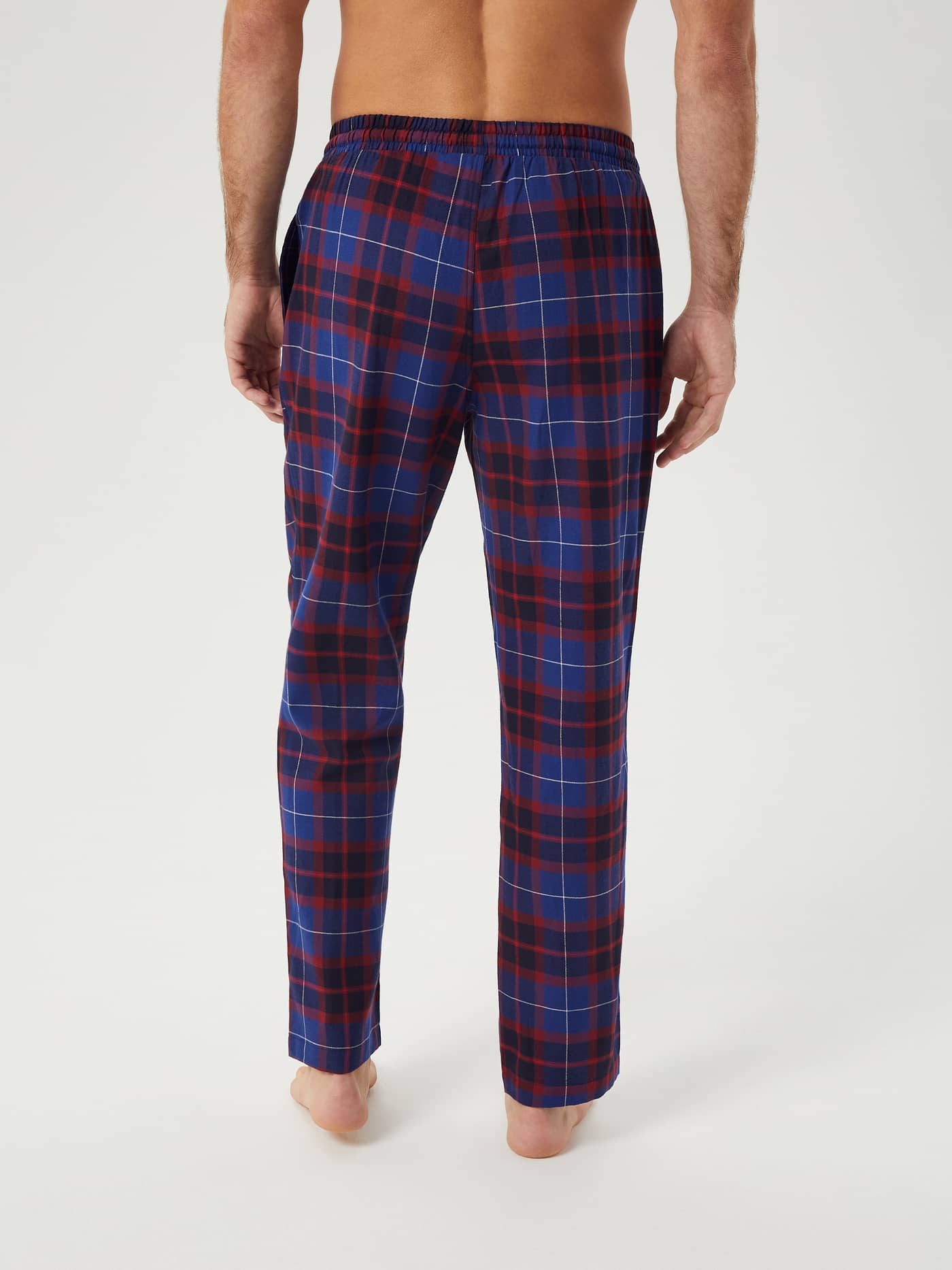 Back view of a man wearing the Core Flannel Pyjama Pants in a blue and red Gaelic Tartan pattern. - Image 4