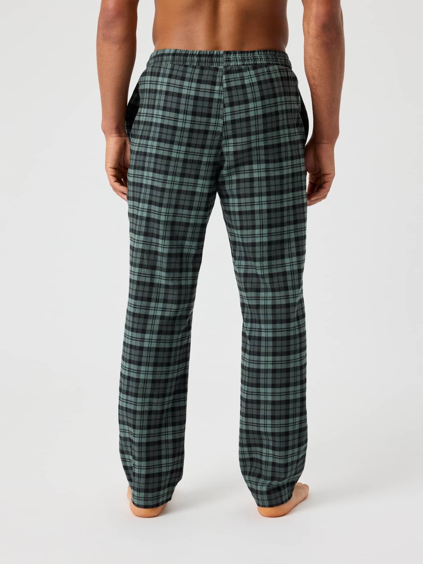 Back view of a man in Björn Borg Core Flannel Pyjama Pants with HS Check 2 (Black, Green) checked flannel and a relaxed fit. - Image 2