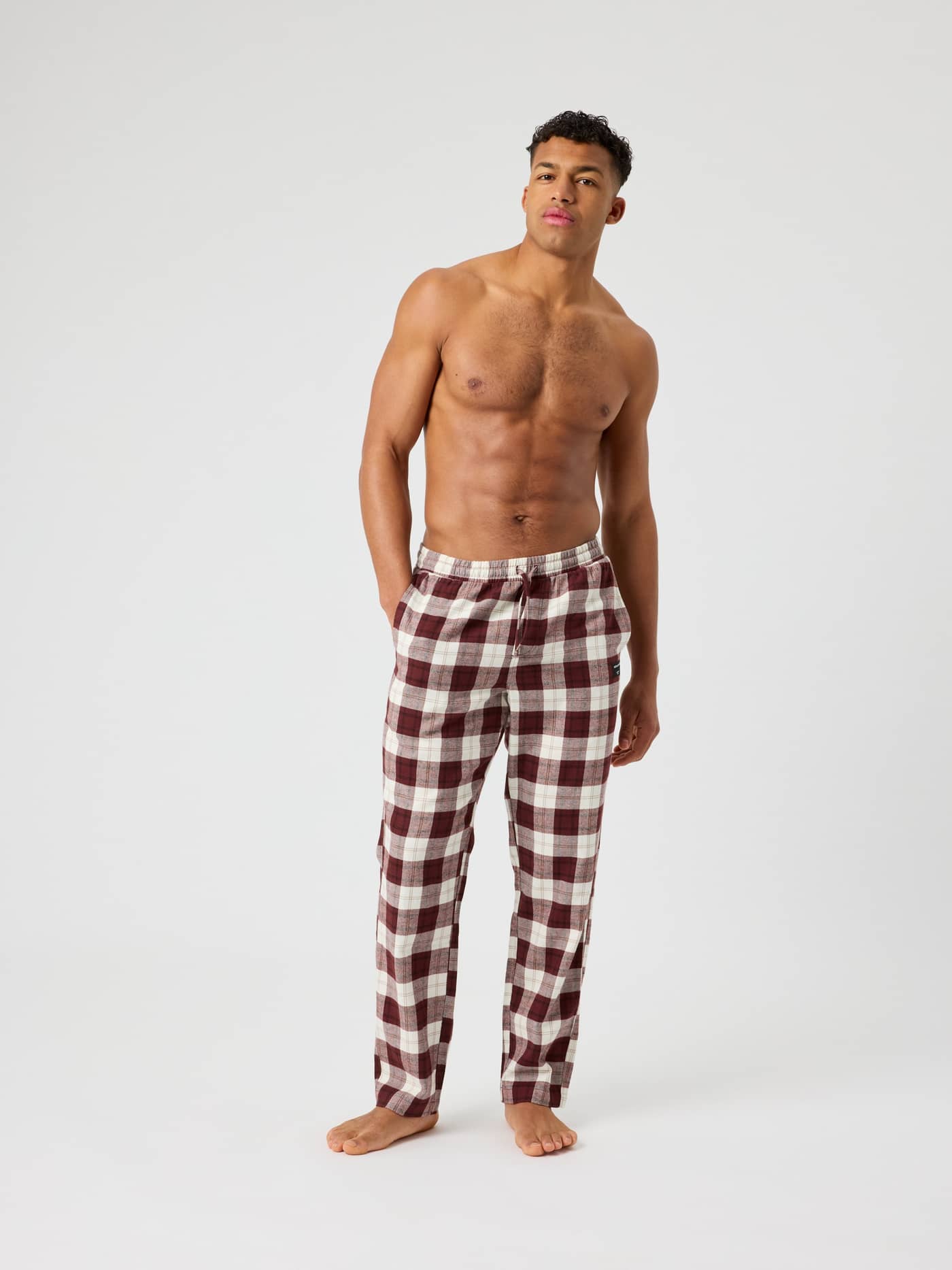 Full-body front view of a man wearing the Björn Borg Core Flannel Pyjama Pants in Forest Tartan 6 (Red). - Image 3