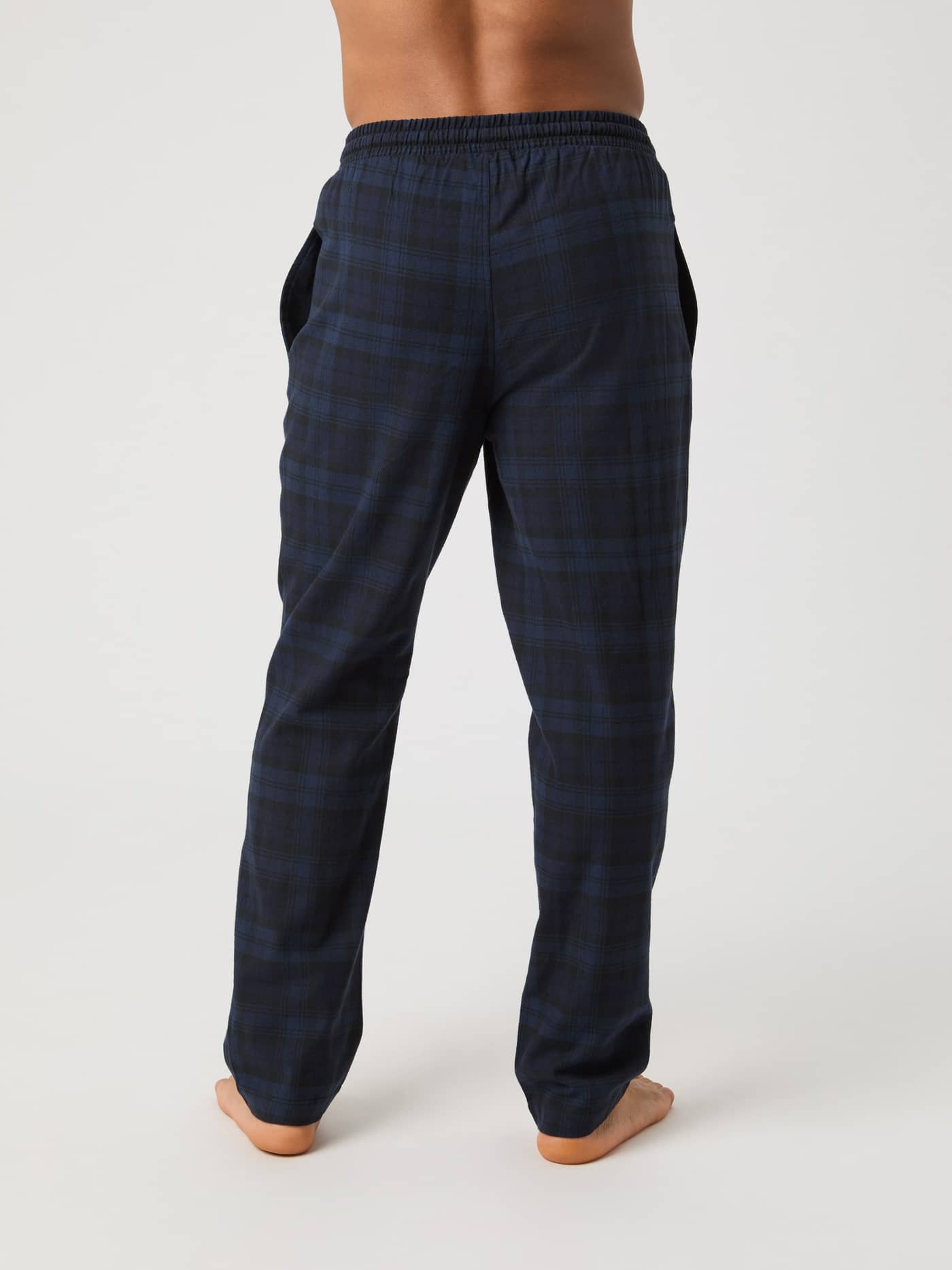 Rear view of a model wearing the Core Flannel Pyjama Pants in a navy classic tartan pattern. - Image 3