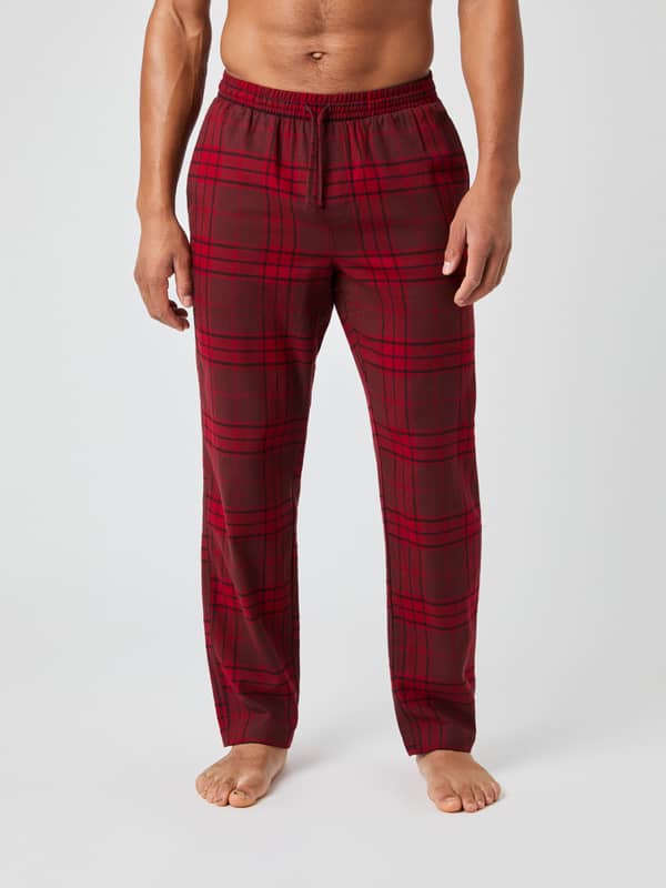 Front view of a model wearing the Core Flannel Pyjama Pants in a red tartan pattern.