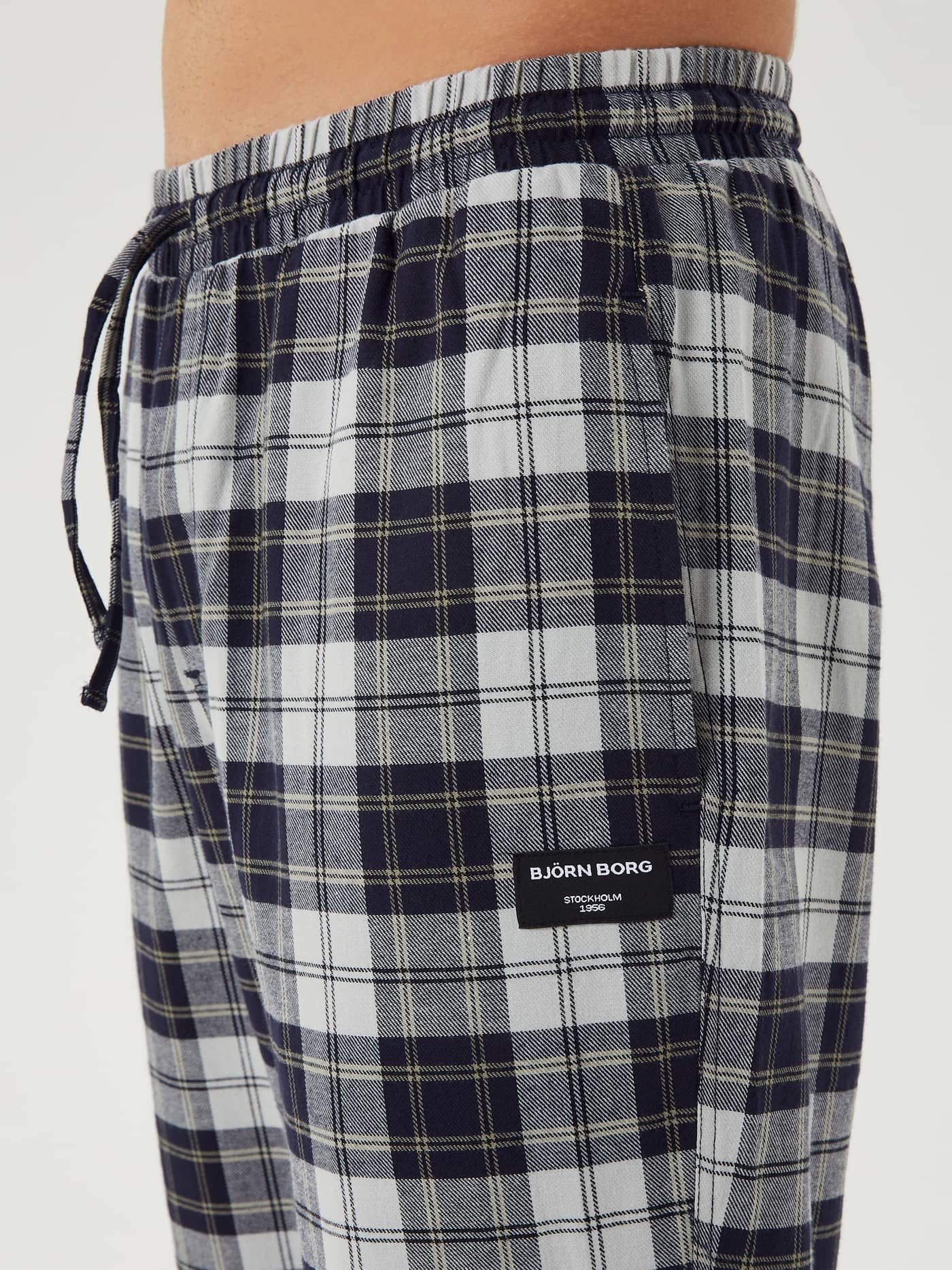 Detailed side view of the Björn Borg Core Flannel Pyjama Pants in Forest Tartan 2, focusing on the drawstring waist and logo. - Image 4