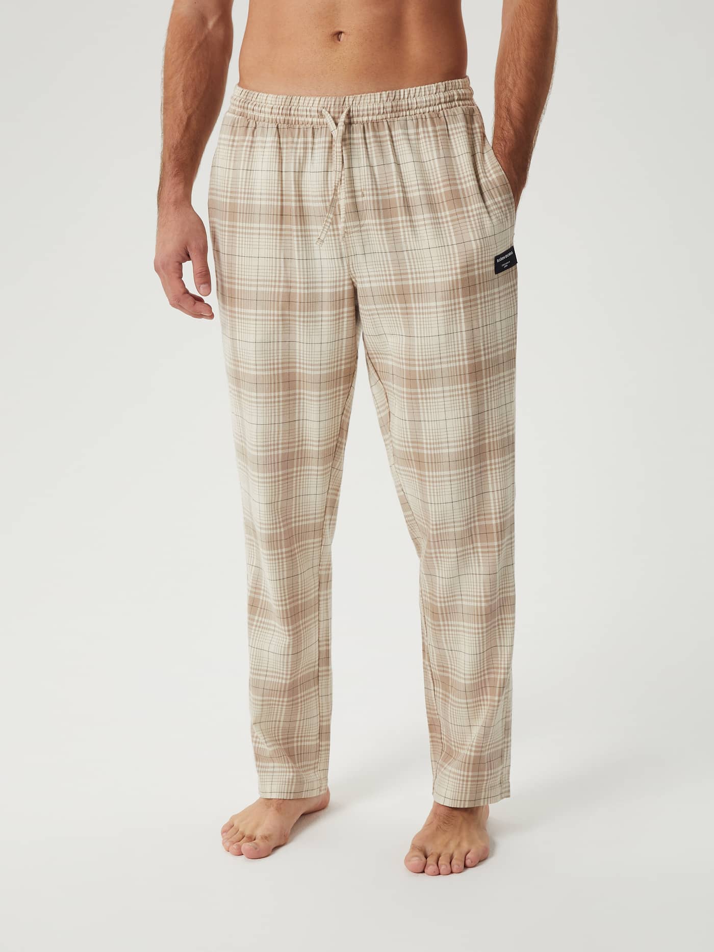 Front view of a model wearing the Björn Borg Core Flannel Pyjama Pants in a beige check pattern. - Image 1