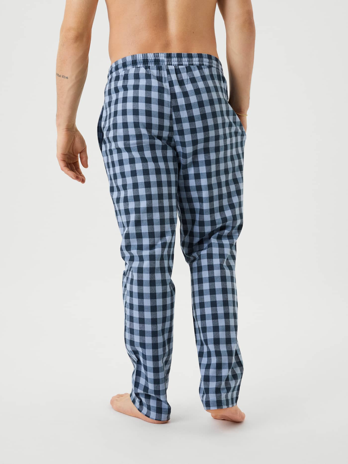 Back view of a man wearing the Björn Borg Core Flannel Pyjama Pants in a blue and navy check pattern. - Image 3