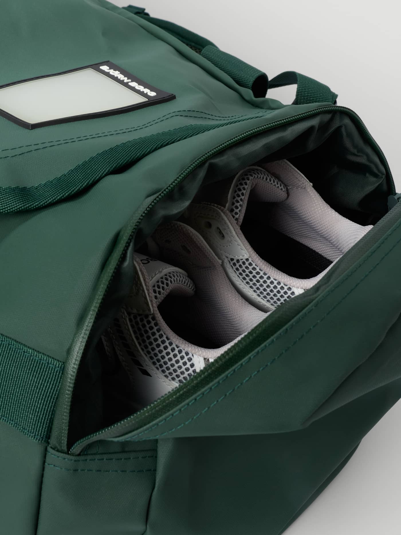 Borg Duffle Bag 55L in Mountain View (Groen) met een wit logo op een zwart label en een vak voor trainingsschoenen. - Image 2