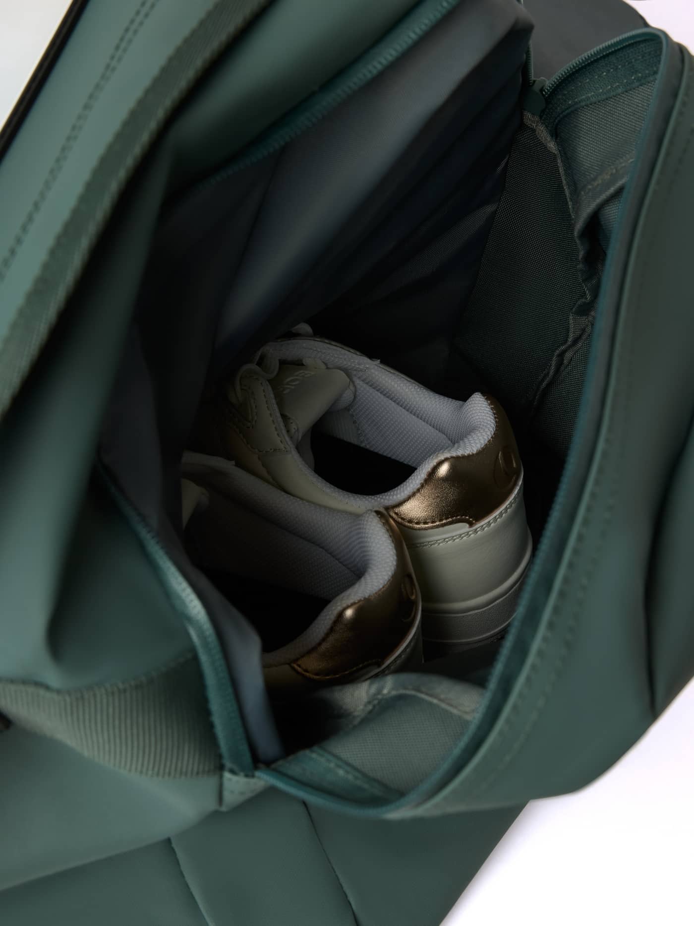 Internal view of the shoe pocket in the Balsam Green (Green) Borg Duffle Bag 55L, showing space for training shoes. - Image 4