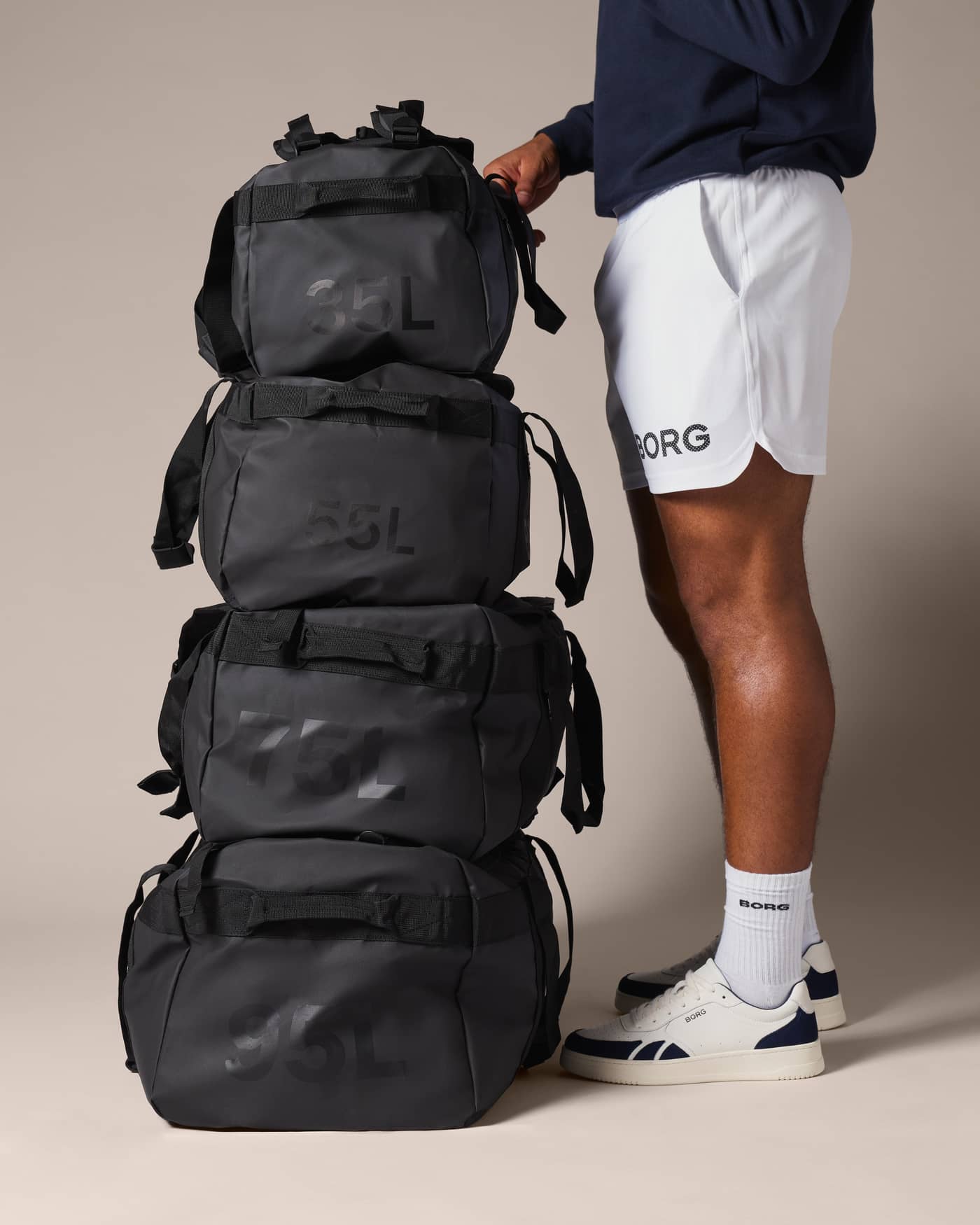 Stack of black Borg Duffle Bags featuring the Borg Duffle Bag 55L in Black Beauty (Black) for training and gym. - Image 8