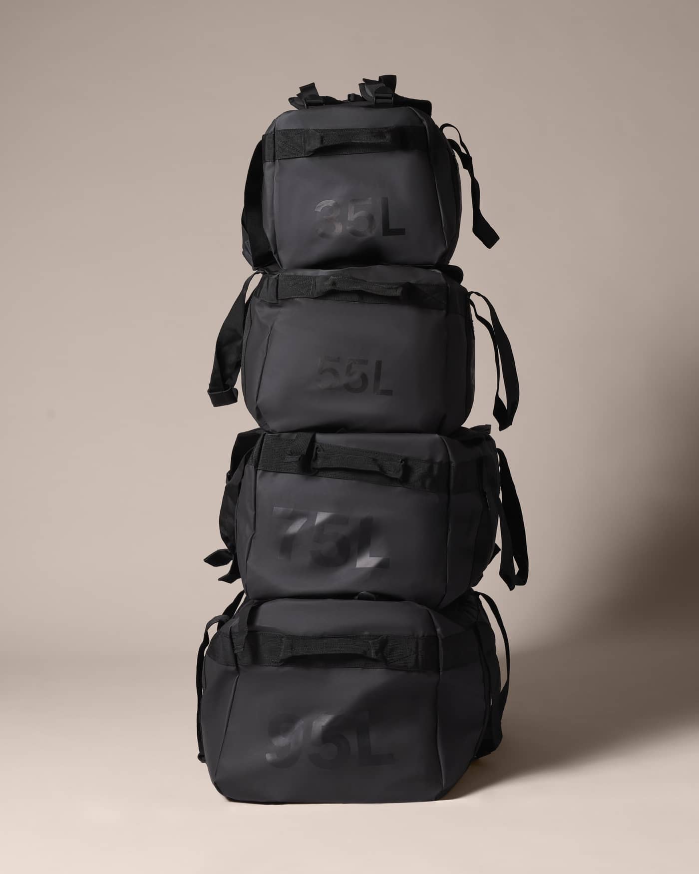 Stacked view of the black Borg Duffle Bag 55L in water-resistant material, shown with other sizes for training. - Image 3