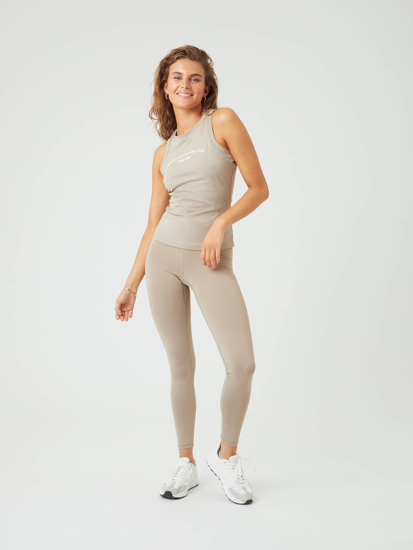 Vue de face d'une femme en Borg Logo Tights beige, un legging extensible conçu pour le training. - Image 1
