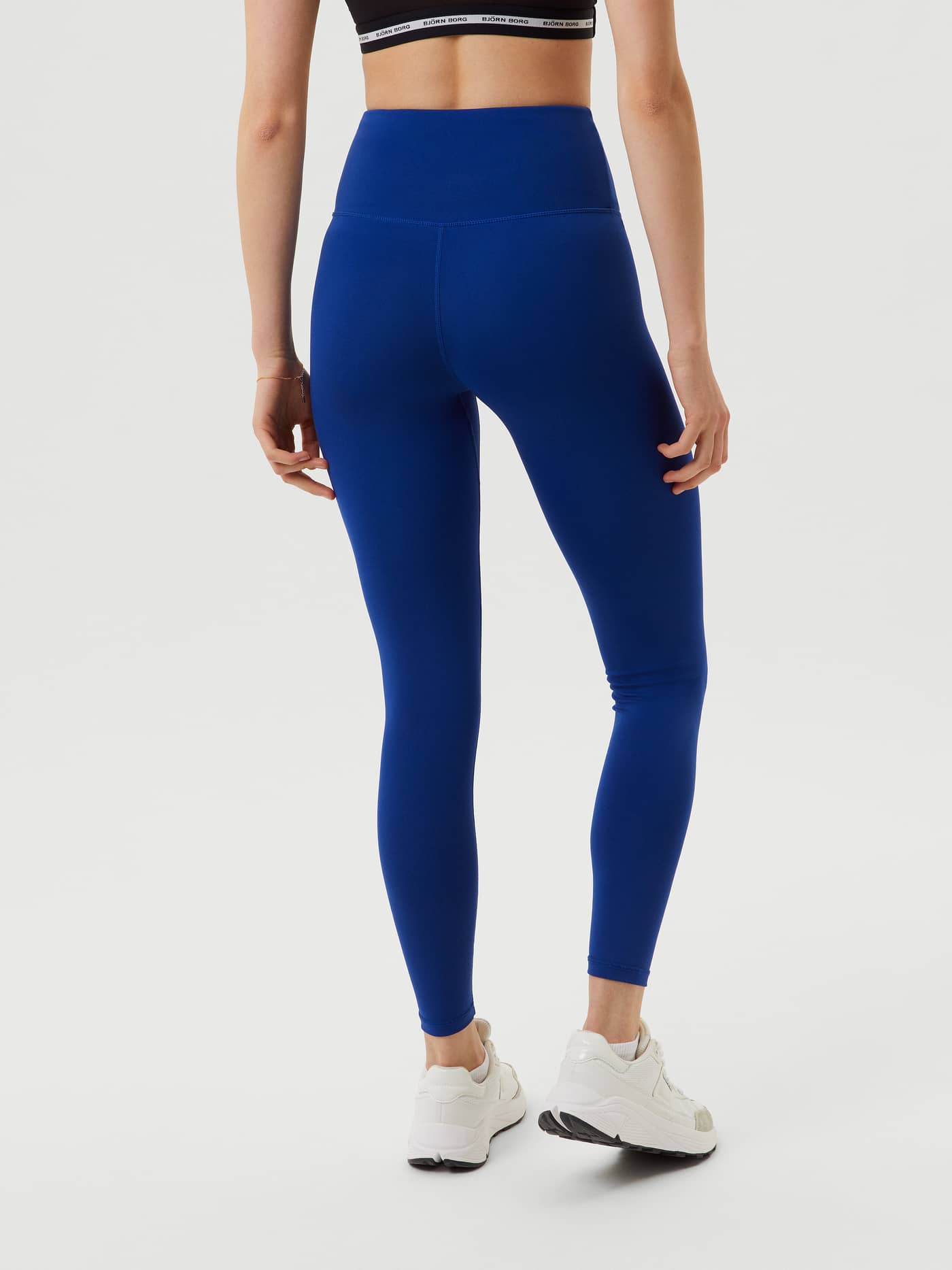 Back view of a woman wearing the high-waist Björn Borg Logo Tights in Sodalite Blue (Blue) for training. - Image 3