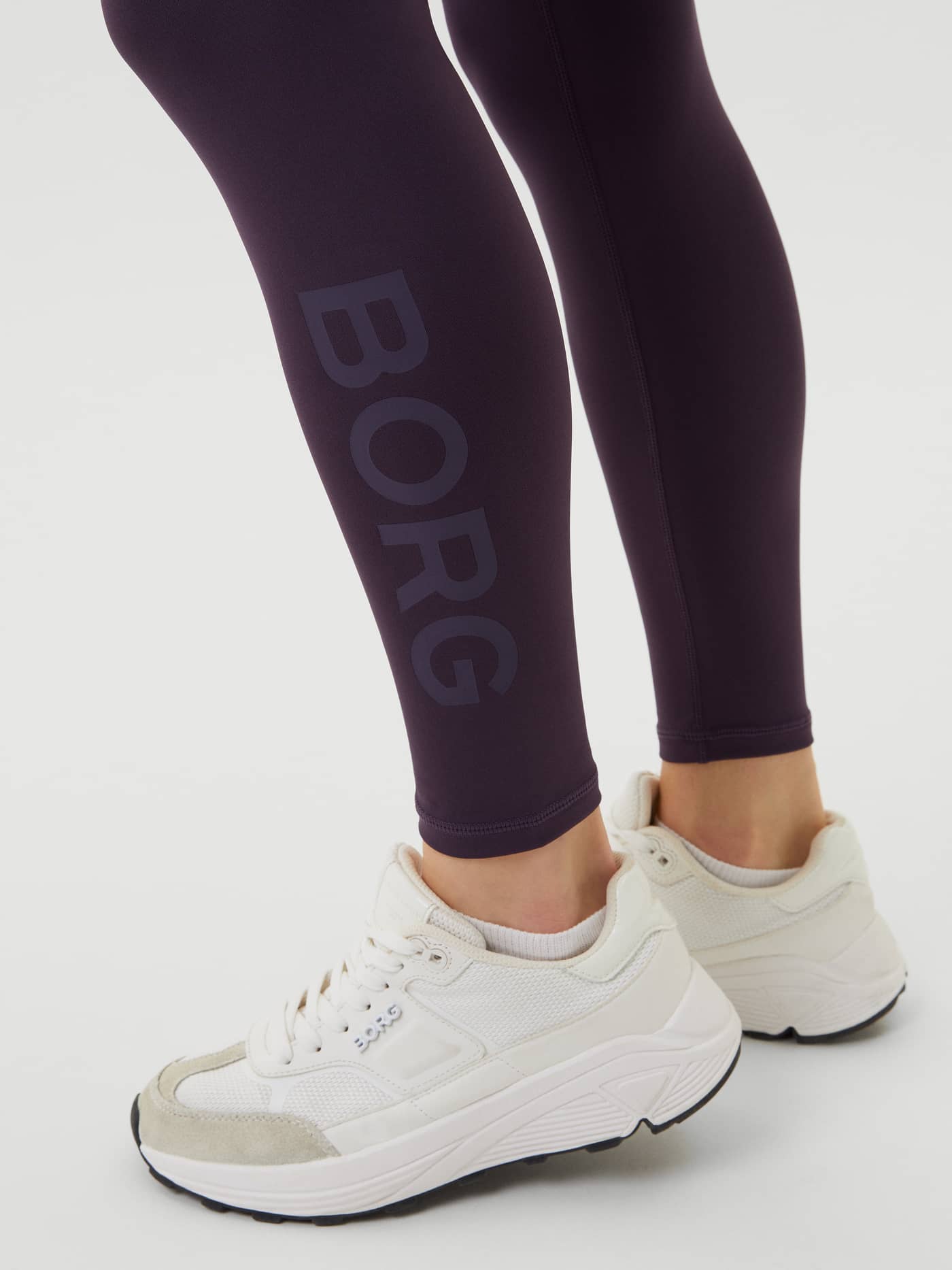 Close-up of the Borg Logo Tights in Nightshade (Purple) featuring a tonal logo on the leg for training performance. - Image 5
